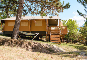Villatent Nomad al Camping La Presqu’île in Francia, con terrazza in legno, amaca e ambiente naturale.