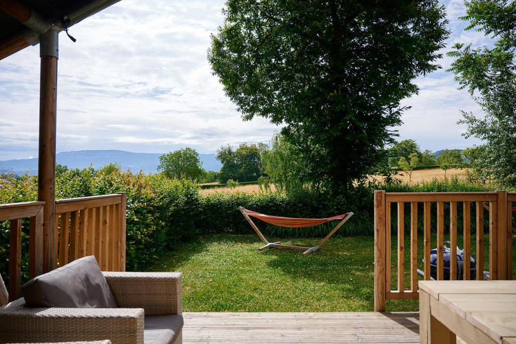 View from safari tent Villatent Wood at Camping Le Coin Tranquille in France with hammock in the garden.