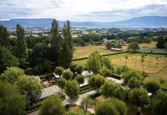 Vista aerea della tenda safari Villatent Wood al Camping Le Coin Tranquille in Francia, tra campi verdi.