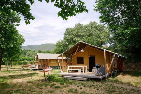 Tiendas safari en Villatent Nomad en Camping La Garenne, Francia, rodeadas de árboles y naturaleza.