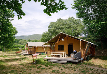 Safari tents at Villatent Nomad in Camping La Garenne, France, surrounded by trees and outdoor scenery.