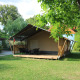 Tenda safari con servizi igienici al Camping Vallee de L'Our in Lussemburgo, circondata dal verde.