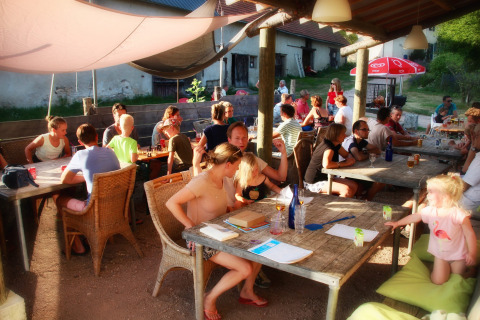 Área común al aire libre en Camping Domaine La Chabanne, familias y niños disfrutan del sol juntos.