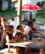Huéspedes disfrutan de una comida y bebida al aire libre en Camping Domaine La Chabanne, Francia.