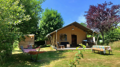 Safari Greenlodge tent met privébadkamer bij Camping Domaine La Chabanne in Frankrijk, omgeven door groen.