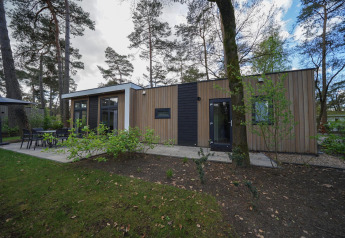 Cube la Mer lodge bij De Zanding, Nederland, met moderne stijl omgeven door bomen en terras buiten.