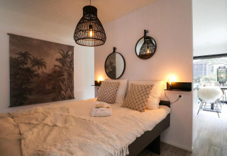Modern slaapkamerinterieur in Wellness Lodge te De Zanding, Nederland, met warme, gezellige sfeer.