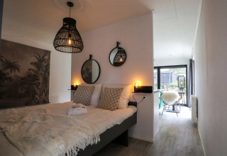 Dormitorio moderno en Wellness Lodge de De Zanding, Países Bajos, con iluminación cálida y decoración elegante.