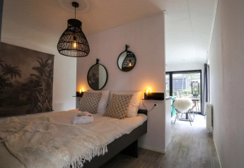 Camera da letto moderna al Wellness Lodge di De Zanding, Paesi Bassi, con illuminazione accogliente e decorazioni.