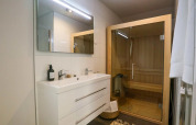 Moderne badeværelse med sauna, dobbelt vask og spejl på Wellness Lodge ved De Zanding i Holland.