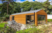 Wellness Lodge ved De Zanding i Holland med moderne træfacade, store vinduer og naturskøn have.