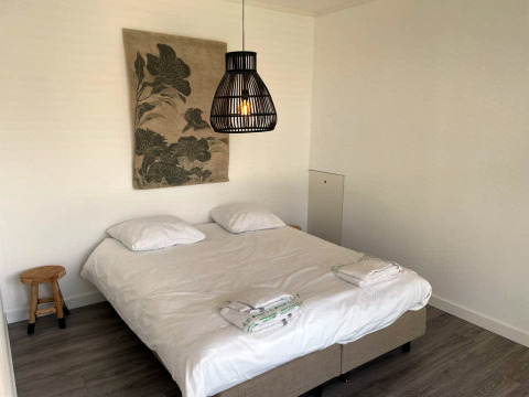 Moderne lodgekamer bij Mode Sauna, De Zanding in Nederland, met tweepersoonsbed en minimalistisch interieur.