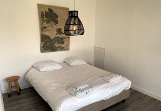 Moderne lodgekamer bij Mode Sauna, De Zanding in Nederland, met tweepersoonsbed en minimalistisch interieur.
