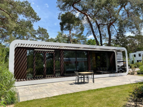 Moderne Lodge Mode Sauna bei De Zanding in den Niederlanden mit Terrasse und von Bäumen umgeben.