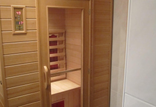 Sauna de madera con puerta de cristal y panel digital en Mode Sauna, De Zanding, Países Bajos.