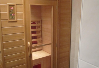 Indendørs sauna med træpaneler og glasdør på Mode Sauna i De Zanding, Holland, set udefra.
