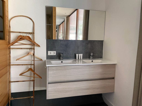 Moderne badkamer bij Mode Sauna, De Zanding, Nederland, met dubbele wastafel, spiegel en bamboerek.
