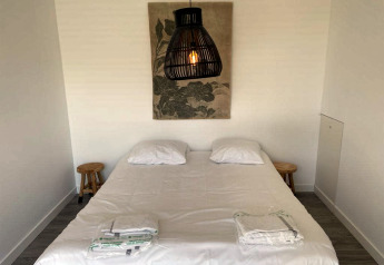 Schlafzimmer im Mode Sauna bei De Zanding, Niederlande, mit Doppelbett, Lampen und Wandkunst.