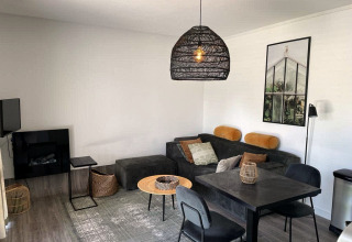 Moderne lodge Mode Sauna bij De Zanding, Nederland, met gezellige zithoek en moderne decoratie.