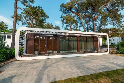 Hedendaagse Mode Sauna lodge bij De Zanding in Nederland, omringd door bomen en modern ontwerp.