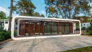 Modernes Mode Sauna-Lodge bei De Zanding in den Niederlanden, umgeben von hohen Bäumen und stilvollem Ambiente.