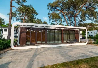 Modernes Mode Sauna-Lodge bei De Zanding in den Niederlanden, umgeben von hohen Bäumen und stilvollem Ambiente.