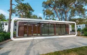 Moderno lodge Mode Sauna en De Zanding, Países Bajos, rodeado de árboles altos y diseño contemporáneo.