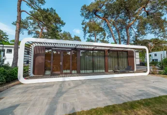 Modernes Mode Sauna-Lodge bei De Zanding in den Niederlanden, umgeben von hohen Bäumen und stilvollem Ambiente.