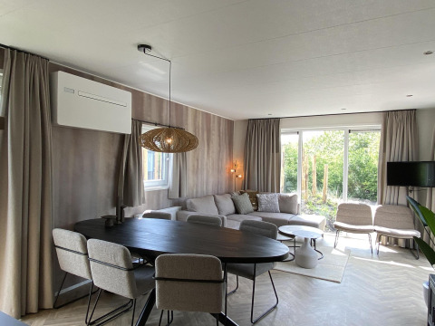 Salón moderno en Zonneweelde Lodge XL de Camping Zonneweelde, Países Bajos, con mobiliario elegante y moderno.