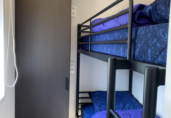 Stanza compatta con letto a castello e porta in legno scuro nella Zonneweelde Lodge XL, Camping Zonneweelde, Olanda.