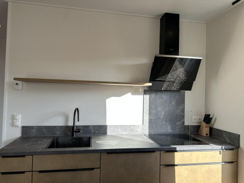 Cocina moderna en Zonneweelde Lodge XL, Camping Zonneweelde, Países Bajos, con encimera de mármol y campana.