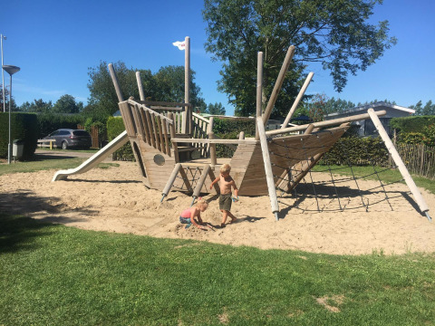 Des enfants jouent sur une grande aire de jeux en forme de bateau à Camping Zonneweelde, Zonneweelde Lodge XL, Pays-Bas.