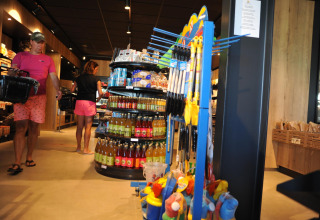 Interior of a supermarket at Zonneweelde Lodge XL, Camping Zonneweelde, Netherlands, with shoppers.