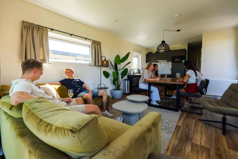 Vrienden ontspannen samen in de Zonneweelde Lodge op Camping Zonneweelde in Nederland, gezellige sfeer.