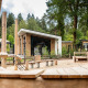 Parque infantil con estructuras de madera frente a cabañas modernas en Resort Veluwe, Silva, Países Bajos, bosque.