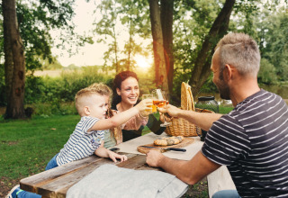 Familie nyder picnic ved et bord i naturen nær Vecht Glamping Lodge, Beerze Bulten, Holland