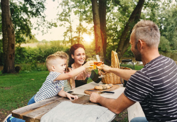 Familia disfrutando de un picnic al aire libre en Vecht Glamping Lodge en Beerze Bulten, Países Bajos