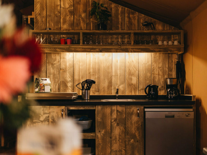 Gemütlicher Küchenbereich in der Vecht Glamping Lodge, Beerze Bulten, Niederlande, mit Holzdekor und Küche.