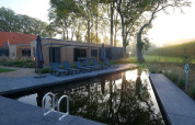Buitenzwembad en ligstoelen bij Amalia Familia-lodge in Hofparken Wiltershaar, Nederland.