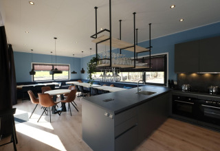 Bright, modern kitchen and dining area in Amalia Familia lodge at Hofparken Wiltershaar in the Netherlands.