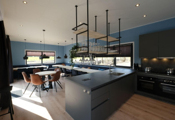 Lichte, moderne keuken en eetruimte in Amalia Familia lodge bij Hofparken Wiltershaar, Nederland.