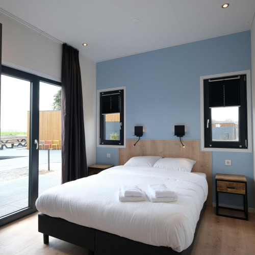 Modernes Schlafzimmer in der Amalia Familia Lodge im Hofparken Wiltershaar, Niederlande, mit Doppelbett.