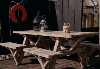 Tavolo da picnic all'aperto su terrazza in legno presso Juttershut, Duynpark Het Zwanenwater, Paesi Bassi.
