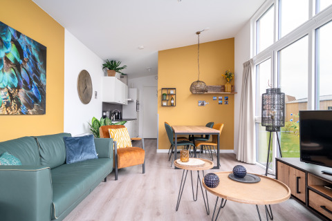 Lyst og moderne indrettet tiny house Knilles Luxe i Tusken de Marren med gul væg og store vinduer.