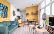 Bright, modern tiny house Knilles Luxe at Tusken de Marren with bold yellow accents and large windows.
