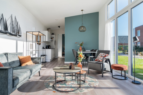 Sala luminosa de la tiny house Knilles Luxe en Tusken de Marren, con muebles modernos y grandes ventanales.