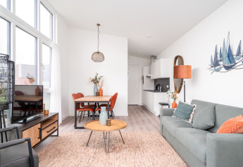 Modernes Wohnzimmer und Küche im Tiny House Knilles Luxe, Tusken de Marren, Niederlande, hell eingerichtet.