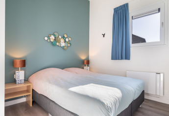 Modernes Schlafzimmer im Knilles Luxe, Tusken de Marren, Niederlande, mit Doppelbett und blauer Wand.