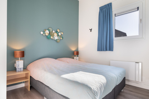 Moderne slaapkamer in Knilles Luxe, Tusken de Marren, Nederland, met tweepersoonsbed en blauwe muur.