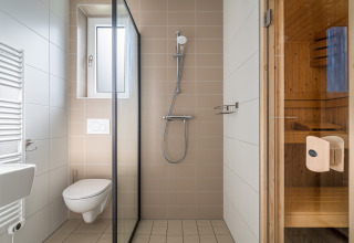 Moderne badeværelse i Knilles Luxe tiny house ved Tusken de Marren, med bruser, toilet og sauna.